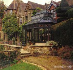 a gazebo sitting in the middle of a garden next to tall buildings and trees