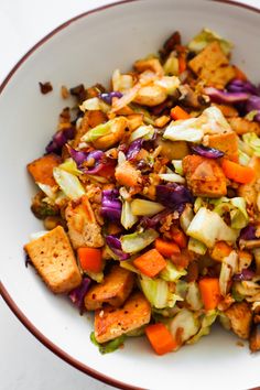 a white bowl filled with chopped vegetables and tofu