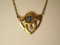 This beautiful Art Deco Style necklace is made of 14K yellow gold. It is handcrafted and features a .88ct bright blue sapphire. Hanging beneath the sapphire is a .08ct diamond. The chain is approximately 9 inches long on each side of the pendant, and attached to each side, rather than through a bail. The pendant is 2cm wide and 1.9cm long. It is 1.5mm thick. Markings: stamped 14K Luxury Blue Necklace With Single Cut Diamonds, Luxury Blue Necklaces With Single Cut Diamonds, Blue Round Necklaces With Single Cut Diamonds, Art Deco Necklace With Single Cut Diamonds As Gift, Art Deco Necklace With Single Cut Diamonds For Gift, Art Deco Blue Jewelry With Single Cut Diamonds, Blue Art Deco Jewelry With Single Cut Diamonds, Gold Tanzanite Pendant Jewelry, Art Deco Gold Sapphire Jewelry