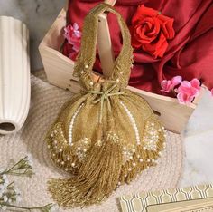 This wedding bridal potli is a beautiful and elegant handcrafted golden potli with fringes and drop pearls on the end. Wedding Handheld Potli Bag, Rectangular Shoulder Bag With Dust Bag For Wedding, Wedding Handheld Potli Gift Bag, Rectangular Wedding Gift Shoulder Bag, Rectangular Wedding Gift Bag, Festive Gold Wedding Bag, Gold Openable Potli Bag For Wedding, Wedding Gift Potli Bag, Gold Pouch Bag For Reception