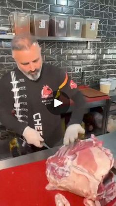 a man cutting up meat in a kitchen