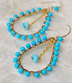 "Sleeping Beauty Turquoise Hoop Earrings. Handcrafted hoop earrings made from 14k gold filled wire shaped and hammered into a graceful dangle hoop earring. The hoop is wire wrapped with exquisite Sleeping Beauty Turquoise 4mm round beads. Omega Earrings In the center swings a cool blue Sleeping Beauty Turquoise rondelle from a 14k gold filled chain. The ear wire is handcrafted from 14k gold fill and adorned with one last Sleeping Beauty Turquoise Bead. Sleeping Beauty Turquoise is considered som Turquoise Dangle Hoop Earrings Wire Wrapped, Turquoise Wire Wrapped Dangle Hoop Earrings, Elegant Handmade Turquoise Hoop Earrings, Turquoise Hoop Jewelry Wire Wrapped, Turquoise Hoop Gemstone Jewelry, Turquoise Gemstone Hoop Jewelry, Turquoise Wire Wrapped Small Hoop Earrings, Turquoise Earrings Gold, Gemstone Hoop Earrings