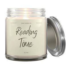 a white candle with the words reading time on it in front of a glass jar