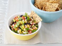 a bowl of corn and black bean salsa with tortilla chips on the side