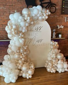 balloons are arranged in the shape of an arch with words on it and white flowers