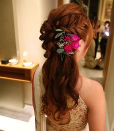 a woman with long hair wearing a flower in her hair