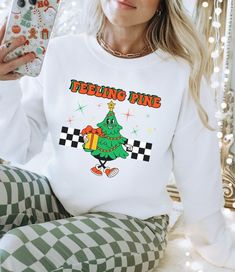 "Embrace the festive spirit with our \"Feeling Pine\" Christmas Sweatshirt, a whimsical and cozy addition to your holiday wardrobe. Crafted from soft, high-quality fabric, this Christmas Tree Sweatshirt combines comfort with a touch of humor. The Funny Xmas Sweatshirt features a charming design that playfully incorporates the pun \"Feeling Pine,\" adding a lighthearted twist to your seasonal style. Whether you're searching for the perfect Christmas Crewneck Sweater, a Christmas Sweater for Women, or a Funny Christmas Sweater to spread holiday cheer, our \"Feeling Pine\" creation is a merry must-have for the season. Bella + Canvas t-shirts and Gilden 18000 heavyweight sweatshirts are featured in my store. They are buttery soft, smooth and so comfy. They are a tried and true favorite of mine Fun Crew Neck T-shirt For Winter, Fun White Sweatshirt For Winter, Winter Tops With Funny Print, Fun Crew Neck Winter Sweatshirt, Fun Winter Sweatshirt With Letter Print, Fun Winter T-shirt With Crew Neck, Funny White T-shirt For Winter, Fun Winter Crew Neck Sweatshirt, White Sweatshirt With Funny Print For Winter