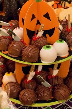 there is a three tiered tray with chocolates and candies in the shape of jack - o'- lanterns