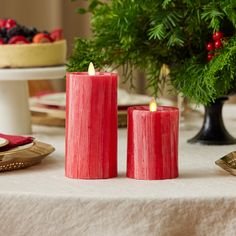 two red candles sitting on top of a table