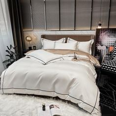 a bed with white sheets and pillows in a room next to a black wall,