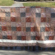 an old quilt is hanging on a wooden bench