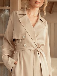 If there ever was a perfect lightweight trench, this is it. Made of a luxurious and flowy fabric, it's a stunning layering piece and can also be worn buttoned up as a dress. The color lies beautifully between beige and tan, providing a soft neutral tone that goes with literally anything in your closet, including all of our capsule pieces. With a tie belt, beautiful horn style buttons, lovely pleats, side slits and a back flap, its intentional design is what sets us apart. Whatever you pair this Chic Beige Outerwear With Belted Cuffs, Elegant Cream Outerwear With Belted Cuffs, Elegant Beige Belted Outerwear, Beige Belted Outerwear For Daywear, Beige Belted Cuffs Outerwear For Spring, Beige Outerwear With Belted Cuffs For Spring, Beige Formal Summer Outerwear, Formal Beige Summer Outerwear, Elegant Neutral Outerwear For Daywear