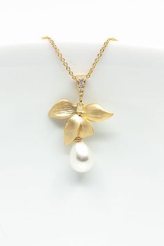 The teardrop-shaped pearl is attached to a delicate flower through which a fine gold-plated chain runs. Product details: Material: brass, gold plated, cubic zirconia Pearl (synthetic) Chain length: 45 cm Pendant: 2.2 cm x 2.2 cm (without loop) The necklace is delivered in a pretty jewelry box. --------------------------------------- You can find more wedding jewelry here: https://www.etsy.com/de/shop/CataleaM?ref=seller-platform-mcnav&section_id=21448206 You can find even more jewelry here: https://www.etsy.com/de/shop/CataleaM Elegant Pearl Chain Flower Necklace, Elegant Flower Necklace With Pearl Chain, Elegant Flower-shaped Pearl Chain Necklace, Teardrop Gold Plated Necklace For Wedding, Gold Plated Teardrop Necklace For Wedding, Elegant Pearl Flower Necklace With Pearl Chain, Elegant Gold Flower Necklace For Wedding, Flower Shaped Pearl Charm Necklace For Wedding, Flower Shaped Pearl Pendant Necklace For Wedding