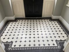 a black and white tiled floor in front of a door