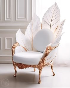 a white and gold chair with leaves on it