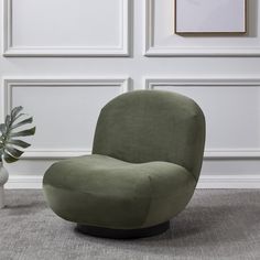 a green chair sitting on top of a rug next to a vase with a plant in it