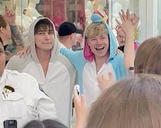 two men in sailor costumes standing next to each other with their arms up and smiling