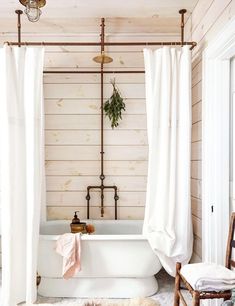 a white bath tub sitting next to a wooden wall