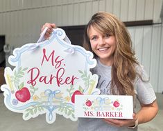 a woman holding up a sign that says, my bakery and mrs baker on it