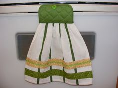 a green and white dress hanging on the oven door