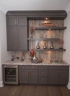 a kitchen with gray cabinets and marble counter tops