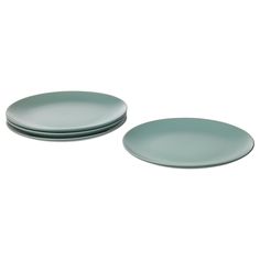 two green plates sitting next to each other on a white surface with no one around them