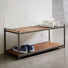 two pairs of shoes sitting on top of a wooden shelf next to a white wall