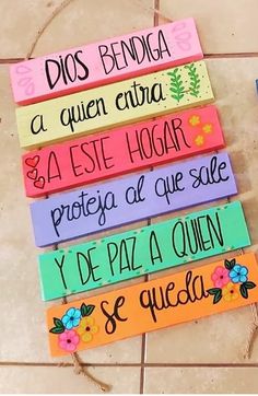 colorful wooden signs with spanish words on them sitting on a tile floor next to each other