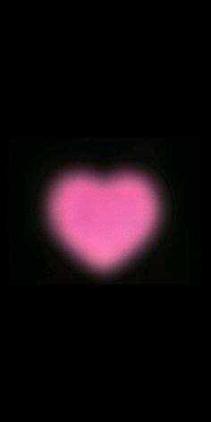 a pink heart shaped object in the dark