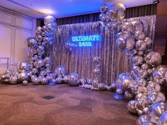 an elaborate backdrop with silver balloons and streamers in the shape of letters that spell out congratulations