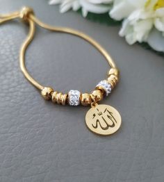 Sparkling Gold Allah Bracelet, Religious Islamic Muslim Jewelry, Quality Stainless Steel Adjustable, Gift for Her, Arabic Women Gifts Delicate and sparkling bracelet featuring Allah name pendant. Adult size adjustable bracelet 18k gold plated All metal parts are stainless steel, It's safe for the skin and won't tarnish or rust over time Gold Stainless Steel Bangle Charm Bracelet, Gold Charm Bracelet With Adjustable Length As Gift, Gold Charm Bracelet With Adjustable Length, Gold Bracelets With Adjustable Length For Gift, Gold Bracelets With Adjustable Length As Gift, Gold Bracelet With Adjustable Length As Gift, Gold Name Bracelet With Adjustable Chain, Gold-tone Stainless Steel Chain Bracelet For Gifts, Adjustable Gold Stainless Steel Bracelet