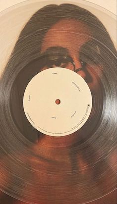 an old record with a woman's face on the side, in front of a white background