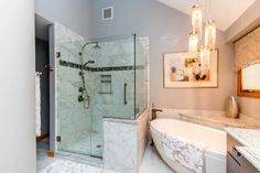 a bathroom with a bathtub, sink and chandelier