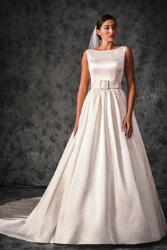 a woman in a white wedding dress posing for the camera with her hands on her hips