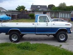 a blue and white truck parked in a driveway