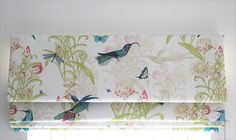 a window with a bird and flower pattern on it's valance, next to the blinds