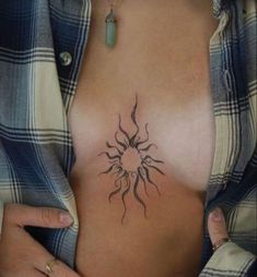 a woman's chest with a sun tattoo on it