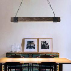 a dining room table with two pictures hanging above it