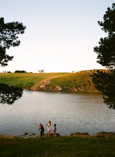 three children fishing on the shore of a lake