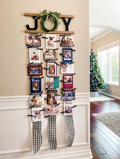 a christmas wreath is hanging on the wall next to some pictures and ribbons that have been hung from them