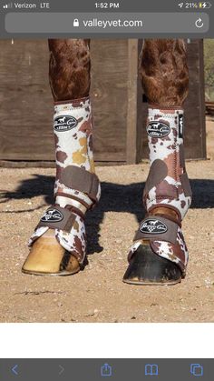 the legs and feet of a person wearing horse boots with brown, white and tan patterns