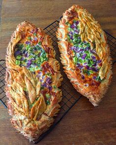 two pieces of pizza sitting on top of a cooling rack next to each other with different toppings