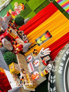 mickey mouse party decorations and food on display at a birthday party in the shape of cars