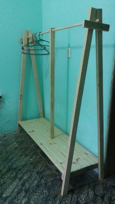 a wooden swing sitting on top of a carpeted floor next to a blue wall