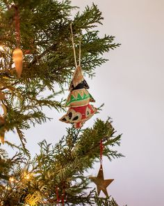 an ornament hanging from the top of a christmas tree with ornaments on it