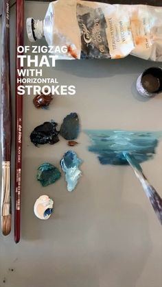 some paint and brushes are sitting on a table with the words, offizzag that is horizontal strokes