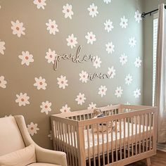 a baby's room with a crib, rocking chair and flower wallpaper