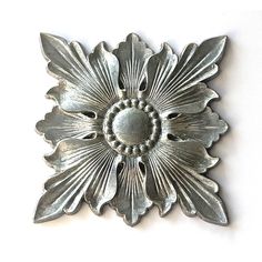 a silver metal flower on a white background