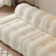 a white couch sitting on top of a hard wood floor