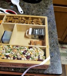 a wooden box filled with lots of different types of food and utensils on top of a counter